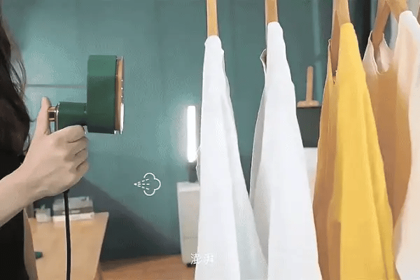 Using the portable steam iron to remove wrinkles from a shirt.